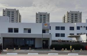 a white building with people walking in front of it at Hotel Algas Marinhas in Aracaju