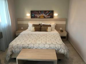 a bedroom with a large bed and two tables at Aloni Studios and Apartments in Lassi