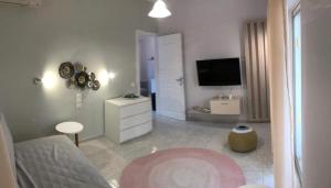 a living room with a bed and a tv at Aloni Studios and Apartments in Lassi