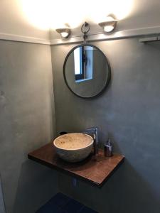 a bathroom with a sink and a mirror on a wall at Aloni Studios and Apartments in Lassi