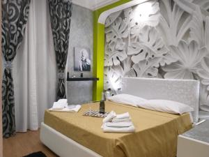 1 dormitorio con 1 cama con toallas en B&B L'Infiorescenza new, en Siracusa
