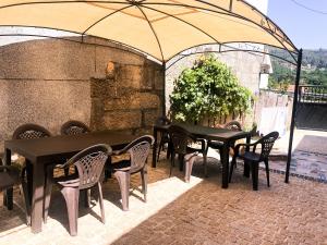 a group of tables and chairs under an umbrella at O Refuxio de la Jerezana in Redondela
