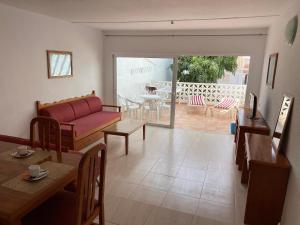 sala de estar con sofá rojo y mesa en villas Canarias, en Adeje