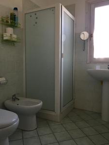 a bathroom with a shower and a toilet and a sink at Mandorleo in Belpasso