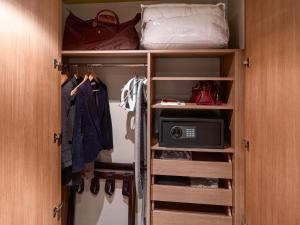 a closet with a door open with a microwave at Aparthotel Adagio Köln City in Cologne