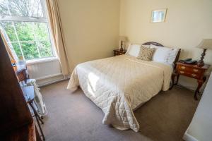 1 dormitorio con cama y ventana en Coolcower House, en Macroom