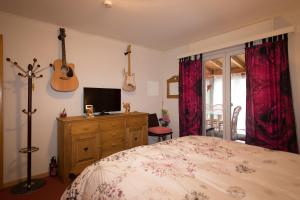 ein Schlafzimmer mit einem Bett und zwei Gitarren an der Wand in der Unterkunft Do mi si la do re in Dorénaz