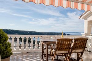 a table and chairs on a balcony with a view at Apartment Starčević in Kampor