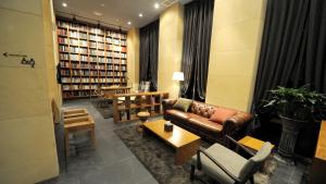 eine Bibliothek mit Ledersofa, Stühlen und Büchern in der Unterkunft Hotel The Designers Jongro in Seoul