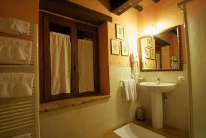ein Bad mit einem Waschbecken und einem Spiegel in der Unterkunft Torre Sangiovanni Albergo e Ristorante da Rosary in Todi