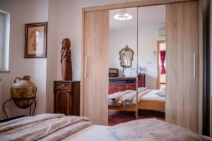 Schlafzimmer mit Glasschiebetür und Spiegel in der Unterkunft Apartment Starčević in Kampor