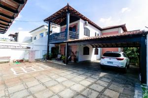 a white car parked in front of a house at Pousada Dunas Braga in Cabo Frio