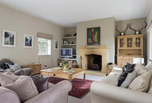 a living room with two couches and a fireplace at Claytons Cottage in Adlestrop