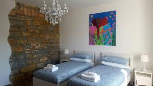 two beds in a room with a painting on the wall at Istrabella Apartment in Koper