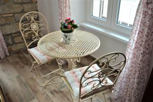 a table and chairs with a vase of flowers on it at Istrabella Apartment -spacious four bedroom apartment in Koper