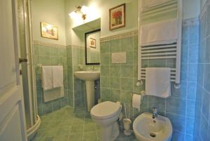 La salle de bains est pourvue de toilettes blanches et d'un lavabo. dans l'établissement Torre Sangiovanni Albergo e Ristorante da Rosary, à Todi