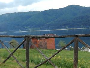 una casa vieja en una colina junto a un lago en Guest House Caracas en Lorica