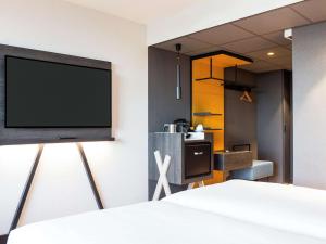 a bedroom with a flat screen tv on a wall at Mercure Amsterdam City Hotel in Amsterdam