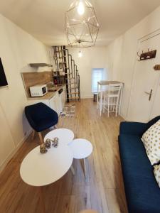 ein Wohnzimmer mit Sofa und Tisch in der Unterkunft Charmant duplex 2 pièces hypercentre de Granville in Granville + 9 Fotos