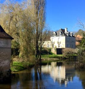 a house and a river in front of a building at LApartment du Perigord in Javerlhac-et-la-Chapelle-Saint-Robert
