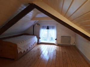 Schlafzimmer im Dachgeschoss mit einem Bett und einem Fenster in der Unterkunft Åkershult in Kvillsfors