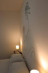 - une chambre avec un lit orné d'une fresque murale représentant des fleurs dans l'établissement Un Sogno Così, à Polignano a Mare