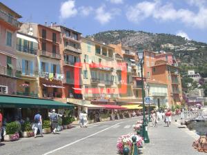 Una calle de la ciudad con edificios y gente caminando por la calle. en Seagulls, en Villefranche-sur-Mer 11 fotos más