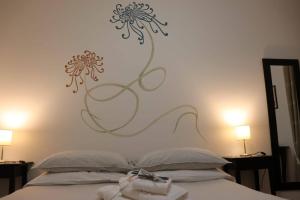 1 dormitorio con 1 cama con flores en la pared en Un Sogno Così, en Polignano a Mare