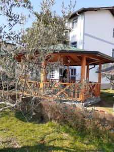a house with a wooden porch in a yard at Villa Dede Nikolla in Durrës
