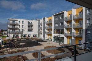 een balkon met uitzicht op een appartementencomplex bij Résidence DOMITYS - L'Athénée in Mont-Saint-Aignan