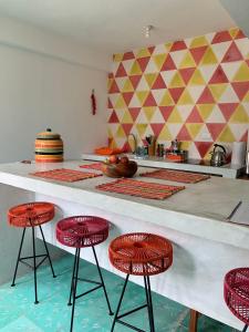 une cuisine avec comptoir et tabourets rouges dans l'établissement CoCo 2 Spacious Apartment Downtown with Garden, à Cozumel