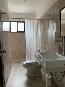 uma casa de banho com um lavatório, um WC e um lavatório. em CoCo 2 Spacious Apartment Downtown with Garden em Cozumel