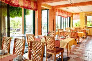 a restaurant with tables and chairs and windows at Ferienhotel Herzog in Neumarkt am Wallersee
