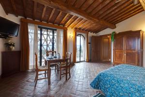 a bedroom with a bed and a table and chairs at Agriturismo La Presura in Strada