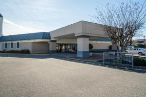 a building with a car parked in front of it at Travelodge by Wyndham Memphis Airport/Graceland in Memphis