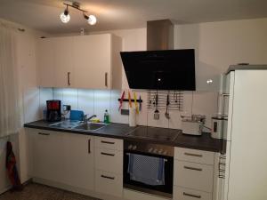 a kitchen with white cabinets and a black counter top at Ferienwohnung-Balaro Apt I EG-Wohnung mit großer Terrasse! in Weil im Schönbuch