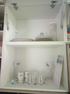 a shelf with dishes and other items in a kitchen at Aptos Farroupilha in Farroupilha