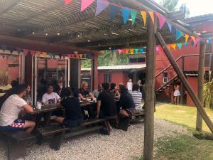Un groupe de personnes assises à des tables sous une pergola dans l'établissement Posada La Pedrera, à La Pedrera 25 autres photos