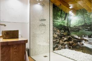 a bathroom with a shower with a painting of a waterfall at Posada rural Fuente Juliana in Barrio de Arriba