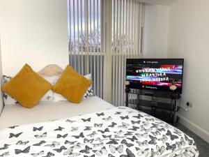 ein Schlafzimmer mit einem Bett und einem TV. in der Unterkunft Edinburgh Ocean Inn in Edinburgh