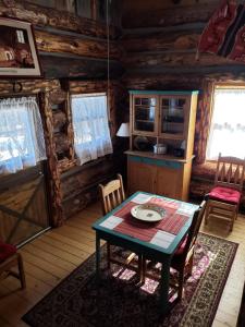 comedor con mesa y sillas en una cabaña de madera en Starry Nights Ranch Bed & Breakfast, en Mancos