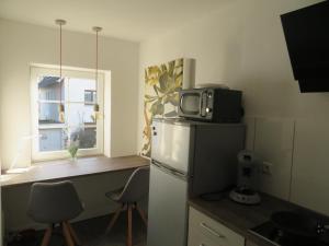 una pequeña cocina con nevera y microondas en Ferienapartment Hugos en Balve
