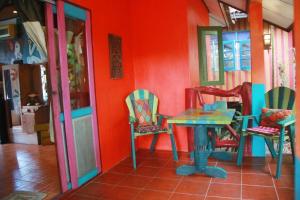 Varinda Resort في شاطئ لاماي: طاولة وكراسي في غرفة بجدار احمر