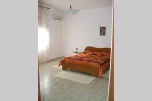 a bedroom with a bed and a mirror at Mariangela's Home in Carbonia