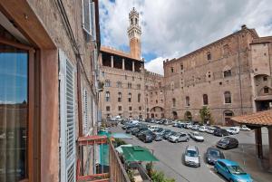 a city street with cars parked in front of a building at Al Mercato B&B in Siena
