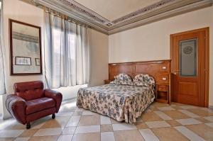 a hotel room with a bed and a chair at Al Mercato B&B in Siena