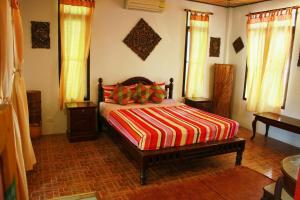 a bedroom with a bed with a colorful striped blanket at Varinda Resort in Lamai