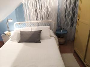 Bett mit weißer Bettwäsche und Kissen in einem Zimmer in der Unterkunft Insua in Malpica