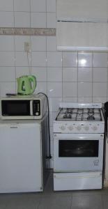 cocina con fogones blancos y microondas en LowCost Zona Sur Mono en San Miguel de Tucumán