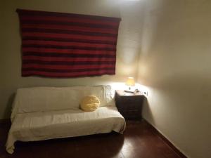 Bett mit gelbem Kissen auf einem Zimmer in der Unterkunft Hamacas Serranas in Salsipuedes